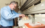 Lane Bourgeois, 12th Flying Wing historian, sifts through a pile of historical documents in his office at Joint Base San Antonio-Randolph June 12, Texas. Bourgeois was honored with the 2019 Wing Excellence in History Programs award from Air Education and Training Command June 12. Lane received Air Education and Training Command's 2019 Wing Excellence in History Programs award for his critical thinking presentations and being the first wing to produce a historical study in the new format.