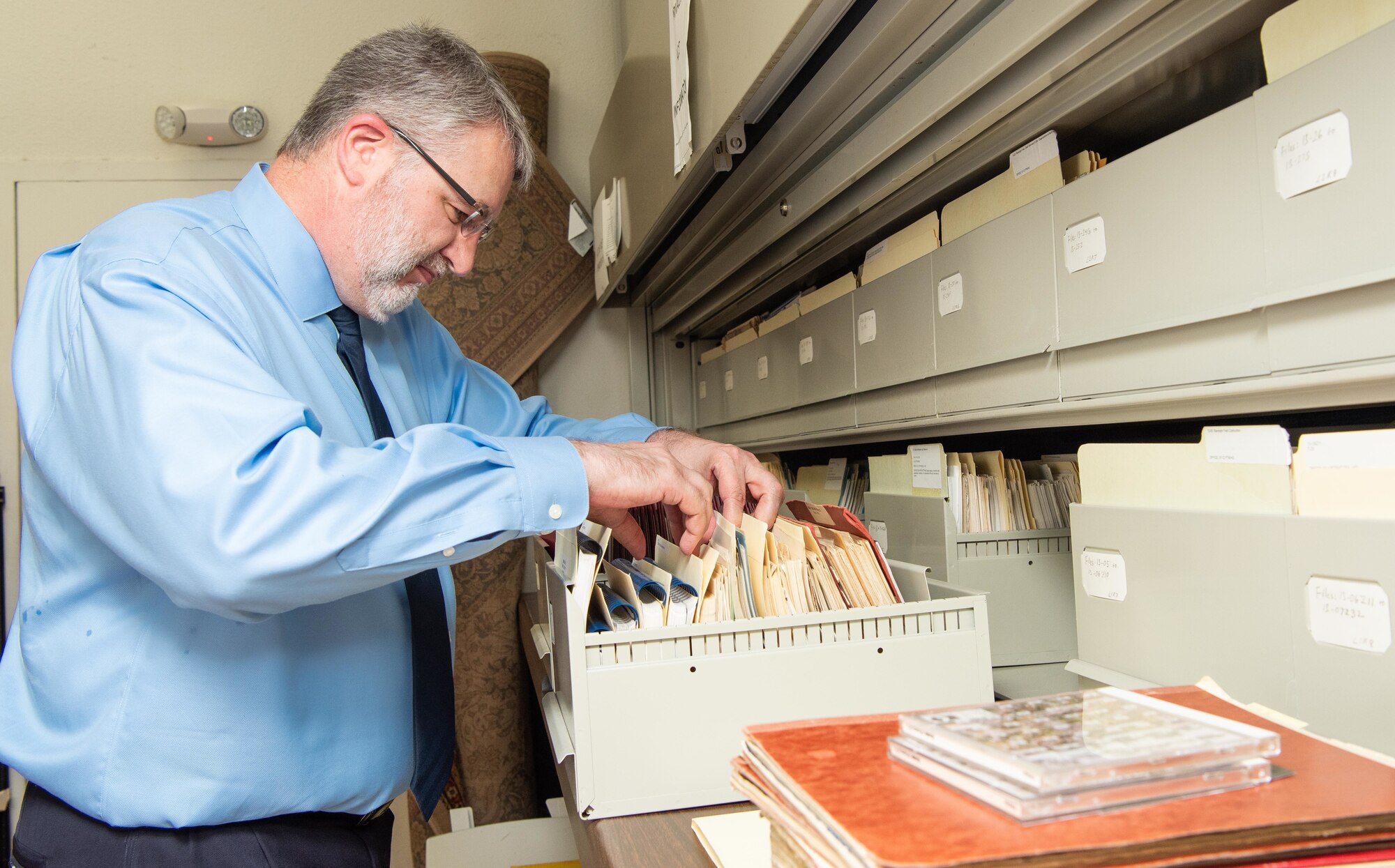 Lane Bourgeois, 12th Flying Wing historian, sifts through a pile of historical documents in his office at Joint Base San Antonio-Randolph June 12, Texas. Bourgeois was honored with the 2019 Wing Excellence in History Programs award from Air Education and Training Command June 12. Lane received Air Education and Training Command's 2019 Wing Excellence in History Programs award for his critical thinking presentations and being the first wing to produce a historical study in the new format.