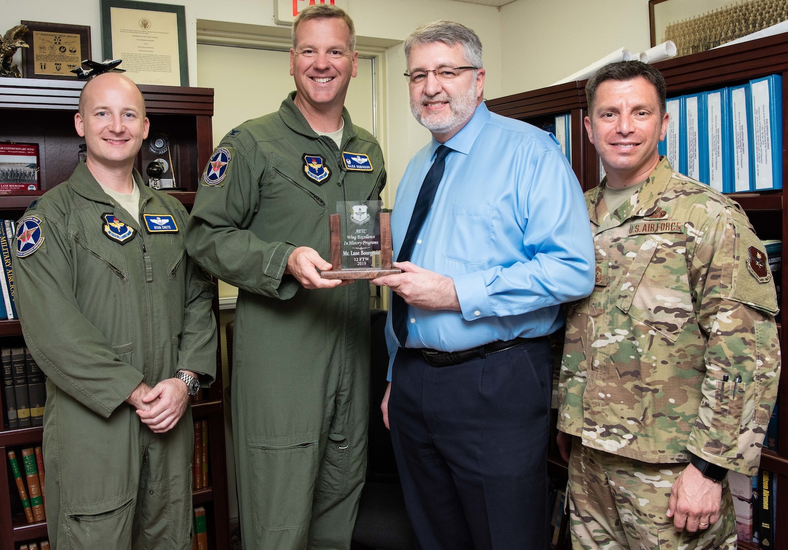 (From left) Col. Mark Robinson, 12th Flying Training Wing commander, Chief Master Sgt. Antonio Goldstrom, 12th FTW command chief, and Lt. Col. Ryan Chute, 12th FTW director of staff, present Lane Bourgeois, 12th FTW historian, with the 2019 Wing Excellence in History Programs award from Air Education and Training Command at Joint Base San Antonio-Randolph June 12. Lane was recognized for his critical thinking presentations and for being the first wing to produce a historical study in the new format.