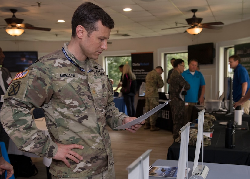 U.S. Army Maj. Peter C. Mueller, Army Futures Command simulations and modeling officer, reads a flyer during the Tactical and Tech Day Expo at Joint Base Langley-Eustis, Virginia, June 12, 2019.