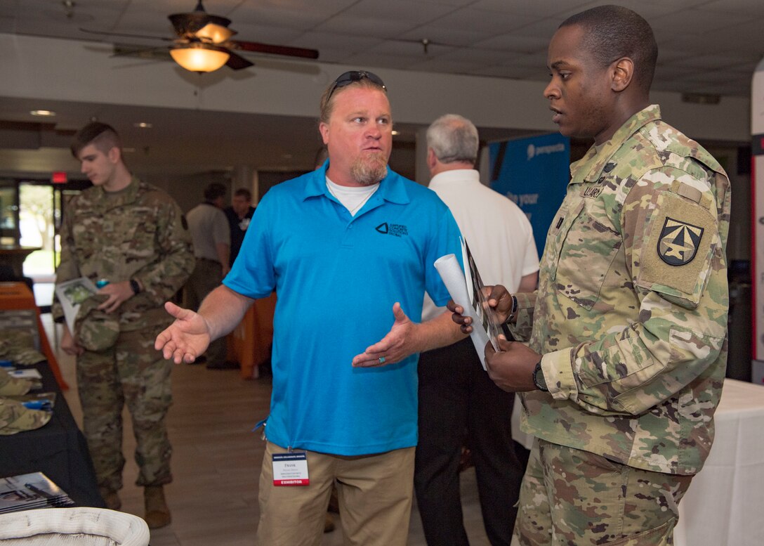 A company representative speaks to U.S. Army Capt. Rodney Bolden, Army Futures Command, Futures and Concept Center operations officer, during the Tactical and Tech Day Expo at Joint Base Langley-Eustis, Virginia, June 12, 2019.