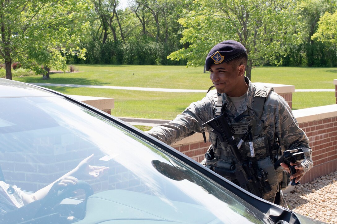 Airman 1st Class Jared Small, 319th Security Forces Squadron installation entry controller, returns an I.D. card to a driver passing through the front gate June 12, 2019, on Grand Forks Air Force Base, North Dakota. Installation entry controllers spend an average of 12 hours on each shift, staying vigilant and ensuring no one enters the base without authorization. (U.S. Air Force photo by Senior Airman Elora J. Martinez)