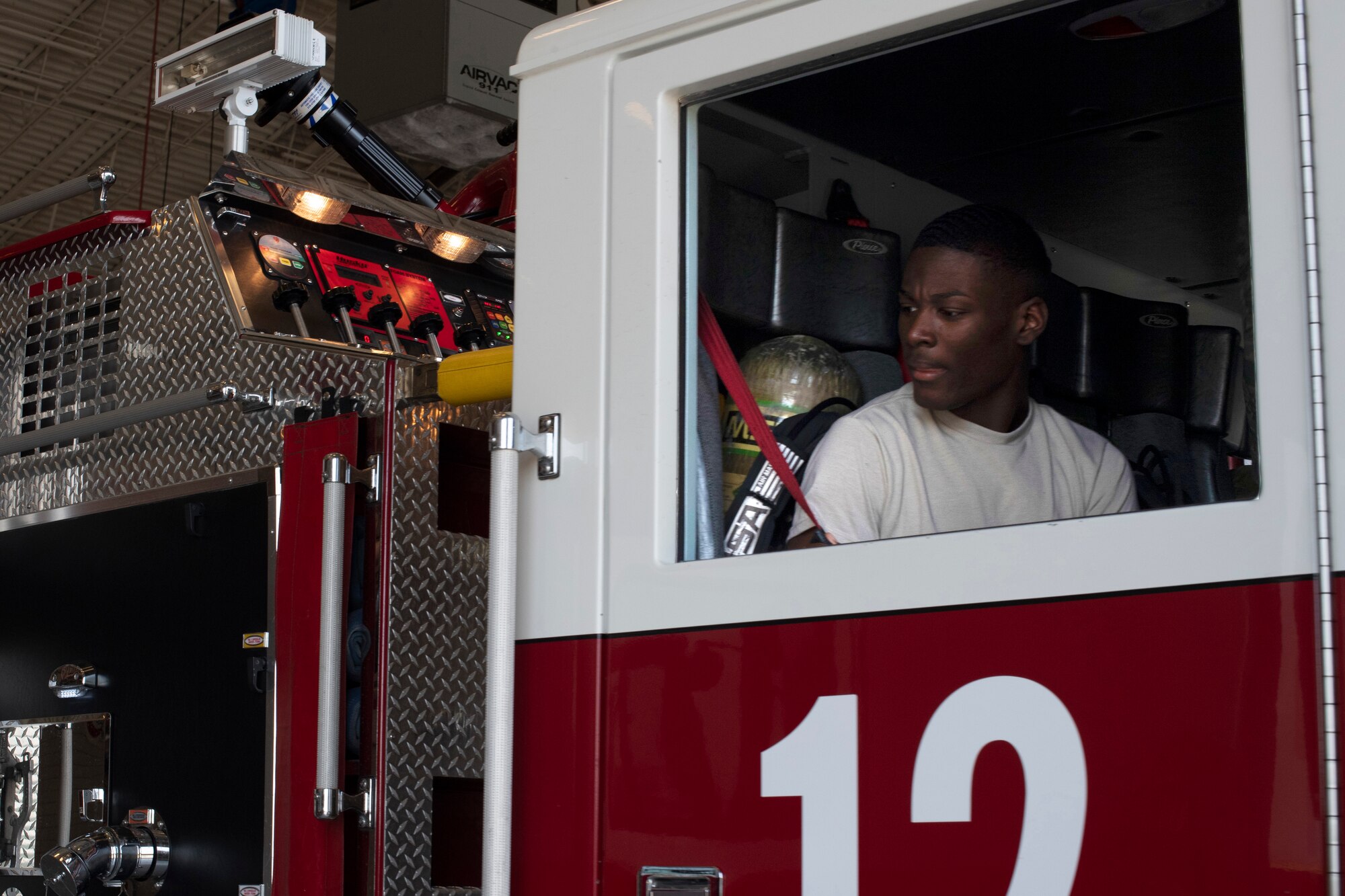 Airman 1st Class Sherman Jackson, 319th Civil Engineer Squadron fire fighter, reaches for a seatbelt as he and a team of fure fighters leave the station to respond to an exercise June 12, 2019, on Grand Forks Air Force Base, North Dakota. The exercise took place near the running trails on base, where a simulated victim fell from his bicycle and needed emergency response and medical attention. (U.S. Air Force photo by Senior Airman Elora J. Martinez)