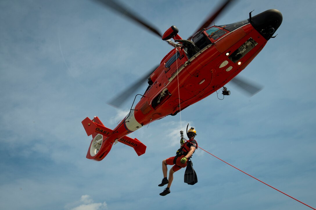 A man rappels down from a helicopter.