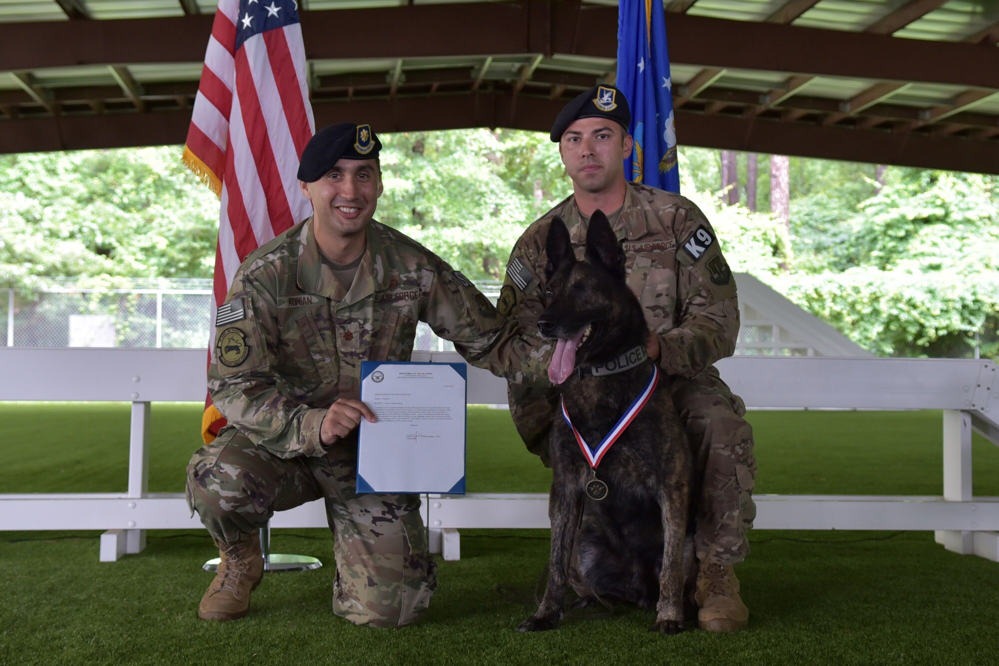 Maj. John-Paul Adrian, 4th Security Forces Squadron commander, left, and Tech. Sgt. Sergio Hernandez, 4th SFS kennel master, present Military Working Dog Ronni P835 with a 4th SFS MWD medal during Ronni’s retirement ceremony on June 11, 2019 at Seymour Johnson Air Force Base, North Carolina.