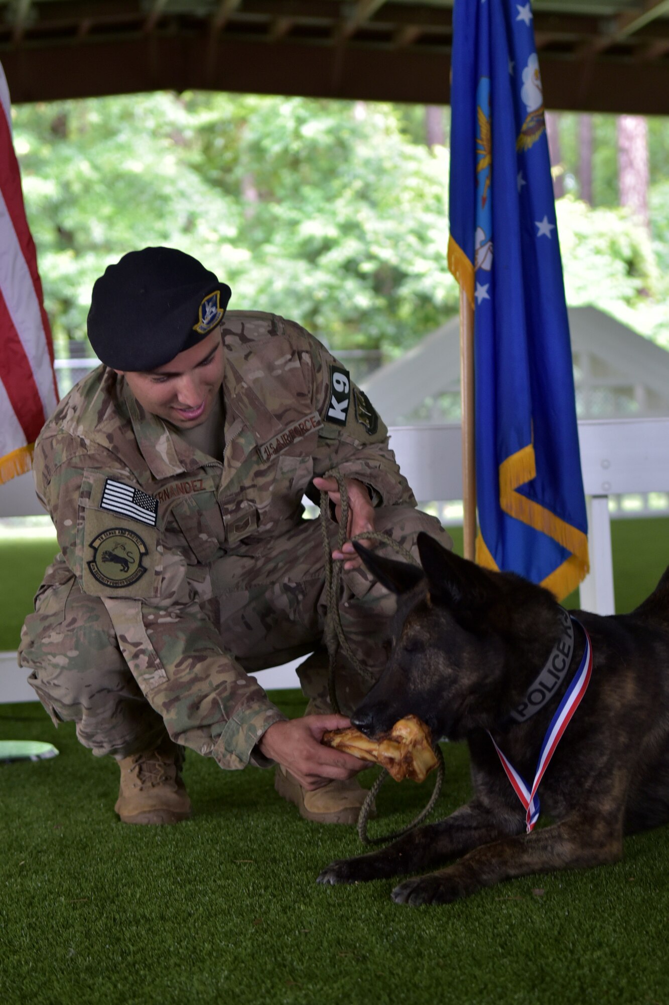 Tech. Sgt. Sergio Hernandez, 4th SFS kennel master, presents Military Working Dog Ronni P835 with a ceremonial bone during MWD Ronni’s retirement ceremony on June 11, 2019 at Seymour Johnson Air Force Base, North Carolina.