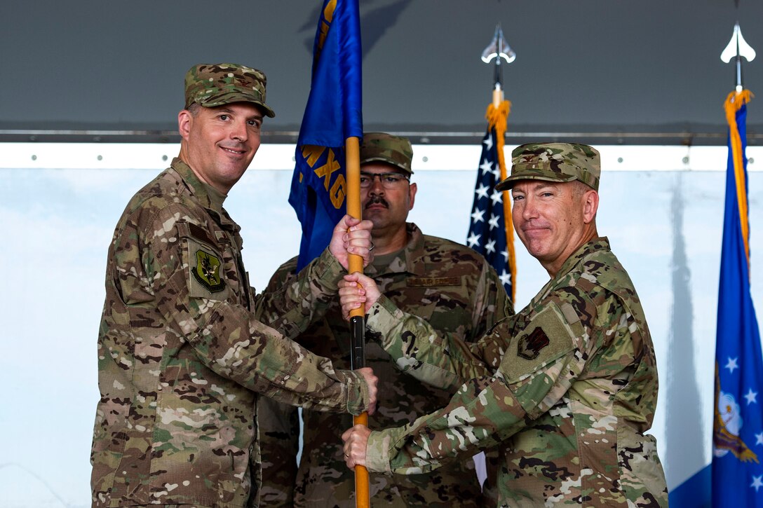 Col. Daniel P. Walls, left, 23d Wing commander, presents the 23d Maintenance Group (MXG) guidon to Col. Stephen Harvey, 23d MXG commander, during a change of command ceremony, June 17, 2019, at Moody Air Force Base, Ga. Harvey joins Moody from Kadena Air Base, Japan, where he was the deputy commander for the 18th Maintenance Group, leading Airmen who maintained combat capabilities for 80 assigned aircraft. (U.S. Air Force photo by Senior Airman Erick Requadt)