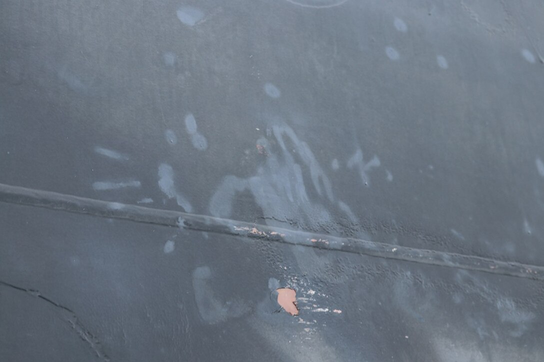 Handprint and other marks on side of oil tanker.