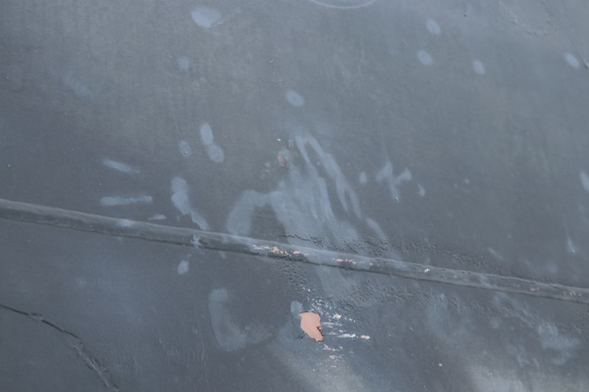 Handprint and other marks on side of oil tanker.