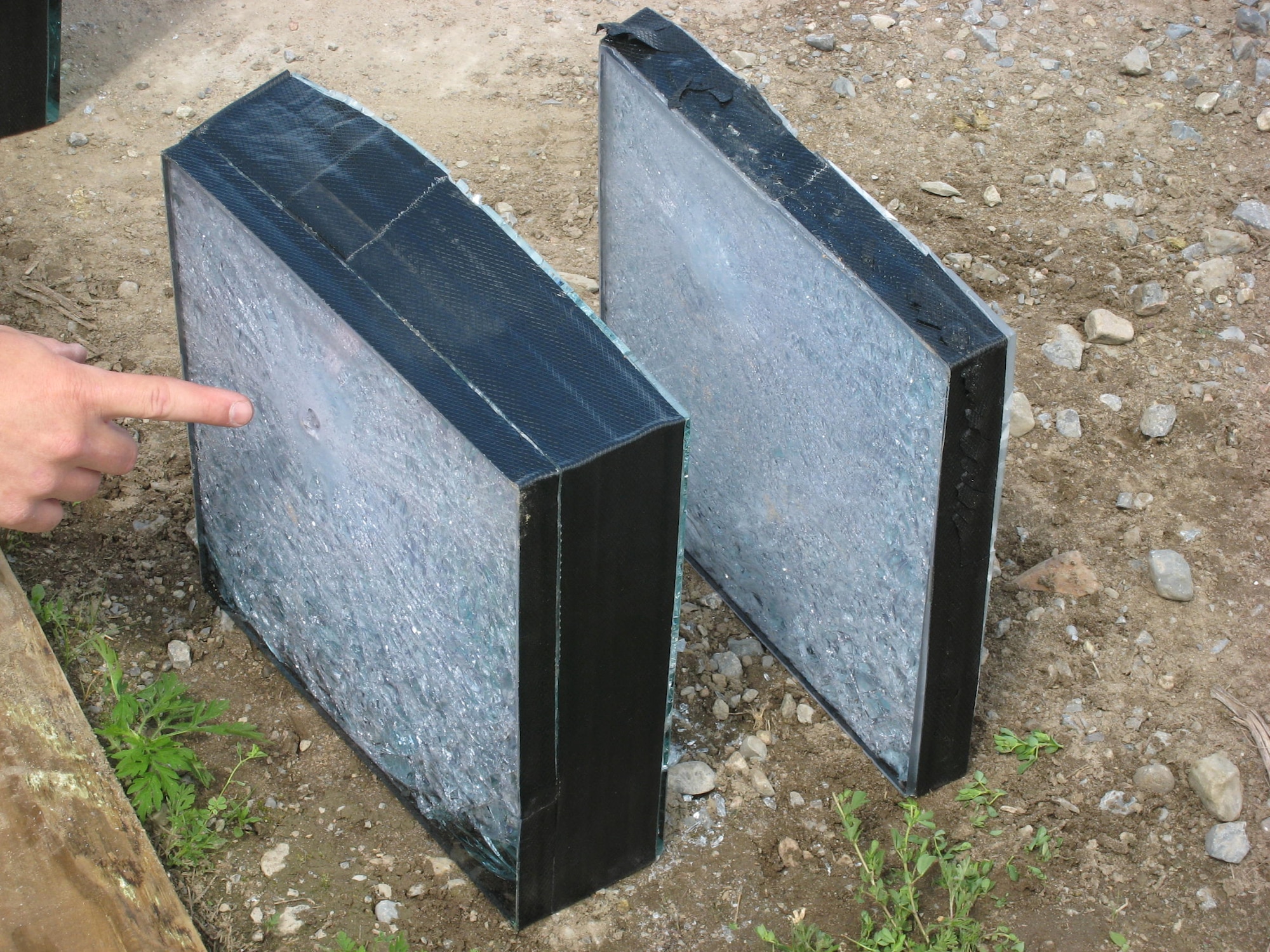 A projectile exit point is shown in the ballistic glass (left). The aluminum oxynitride transparent ceramic armor is shown (right) with a bulge and no exit from the projectile. (Courtesy photo)