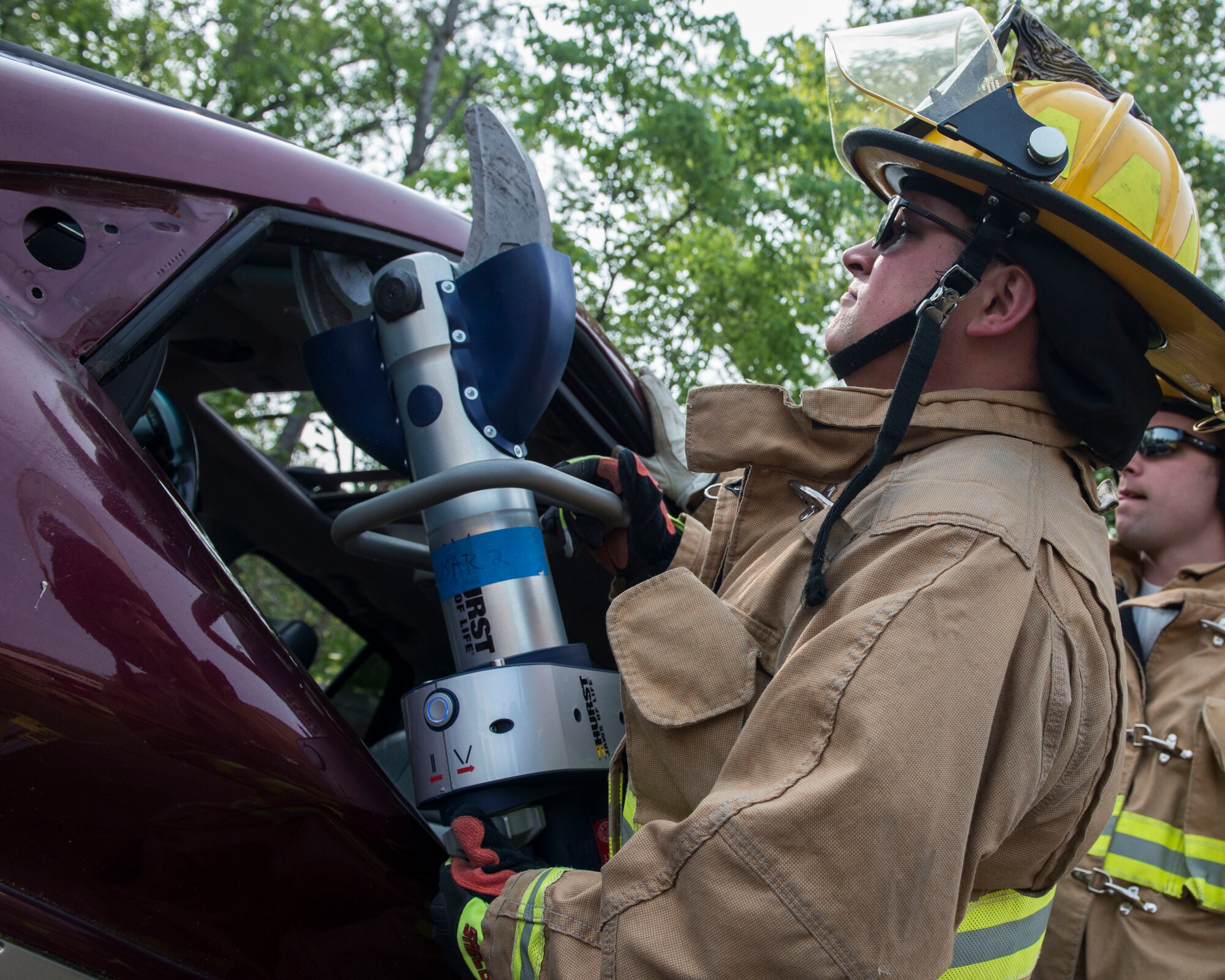 A Firefighter assigned to the 103rd Civil Engineer Squadron, Connecticut Air National Guard uses jaws of life equipment to remove a door from a vehicle as part of an auto accident scenario during a rescue strike team exercise, June 1, 2019 in East Granby, Conn. Air Guard firefighters trained with members of several local fire departments to ensure continuity in training across departments. (U.S. Air National Guard photo by Tech. Sgt. Tamara R. Dabney)