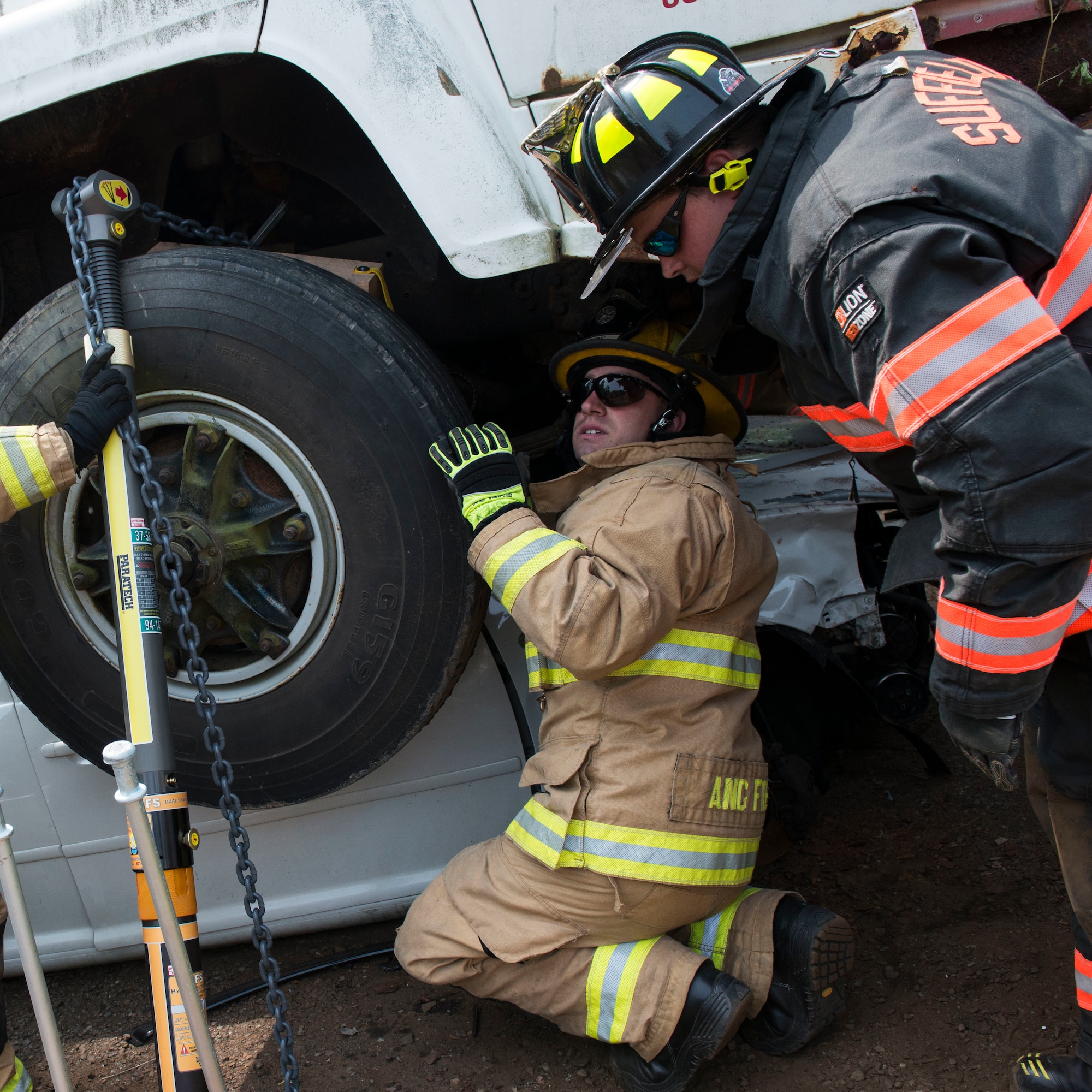 Firefighters assigned to the 103rd Civil Engineer Squadron work alongside firefighters from various other departments to remove an oil tanker off of another vehicle as part of an auto accident scenario during a rescue strike team exercise, June 1, 2019 in East Granby, Conn. The firefighters trained with members of several local fire departments to ensure continuity in training across departments. (U.S. Air National Guard photo by Tech. Sgt. Tamara R. Dabney)