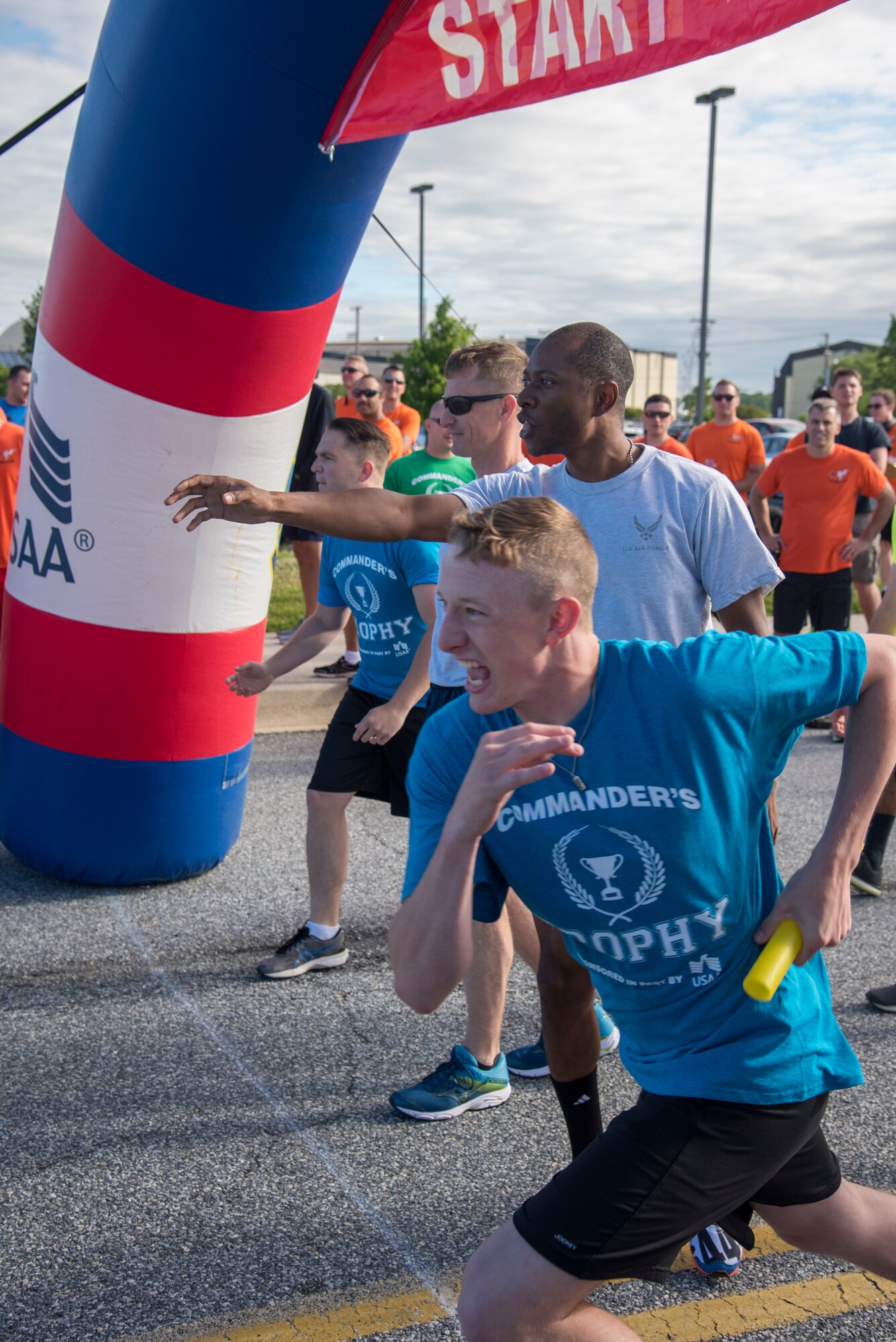 Airmen wait to receive the baton before sprinting to their teammate June 14, 2019 at Dover Air Force Base, Del. The relay race kicked off the event where 4 teams compete against one another for each heat. (U.S. Air Force photo by A1C Jonathan Harding)