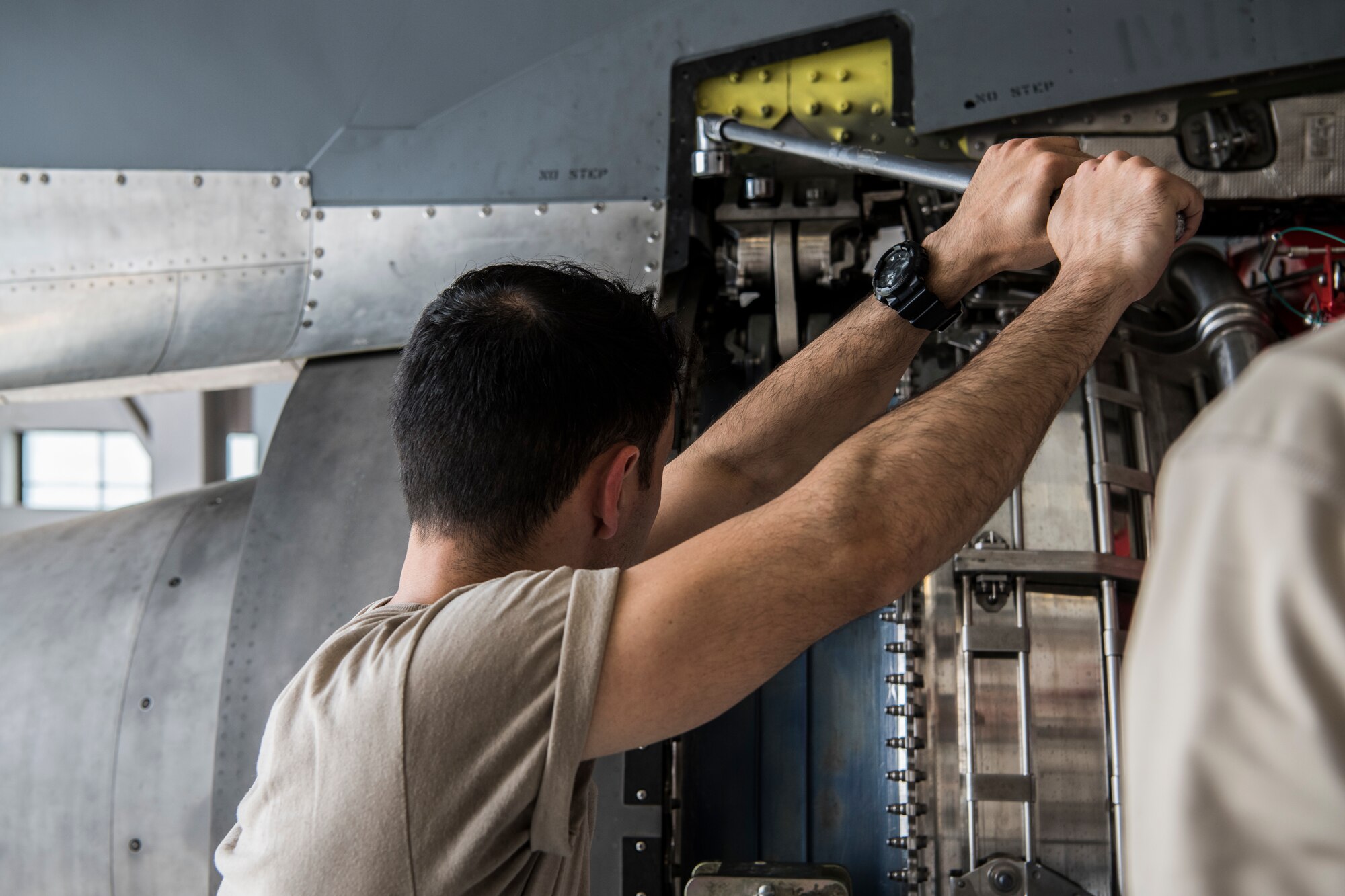 Senior Airman Chad Helminiak, 60th Aircraft Maintenance Squadron aerospace propulsion journeyman, unscrews a bolt June 6, 2019, Dover Air Base, Del. Unscrewing the bolts is the last step that must be completed in order for the C-5M Super Galaxy engine to be lowered. (U.S. Air Force photo by Senior Airman Christopher Quail)