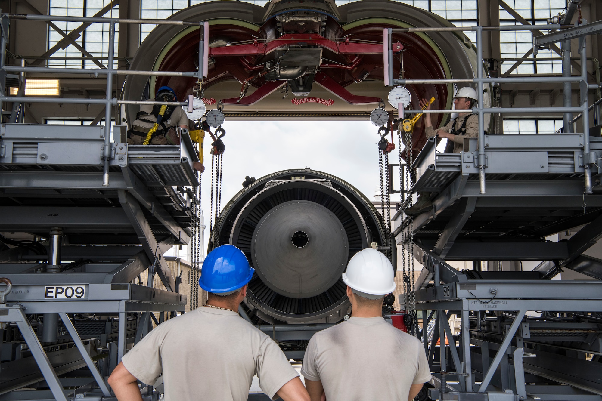 Airmen from the 60th Aircraft Maintenance Squadron and 725th Air Mobility Squadron work together to lower a C-5M Super Galaxy engine during an engine-changing course June 6, 2019, Dover Air Force Base, Del. Airmen attending the course took turns supervising, raising and lowering the engine so that each one got a chance to get experience the different positions. (U.S. Air Force photo by Senior Airman Christopher Quail)