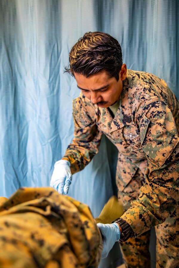 U.S. Navy Petty Officer 3rd Class John Lopes, right, a corpsman with Marine Wing Support Squadron 473, Marine Aircraft Group 41, 4th Marine Aircraft Wing, examines a patient’s ankle movement at Canadian Forces Base Cold Lake, Canada, June 14, 2019, in support of Sentinel Edge 19. U.S. Navy Corpsman play a significant role in Reserve Marines’ annual trainings to ensure the Reservist are healthy and able to continue their mission. (U.S. Marine Corps photo by Sgt. Andy O. Martinez)