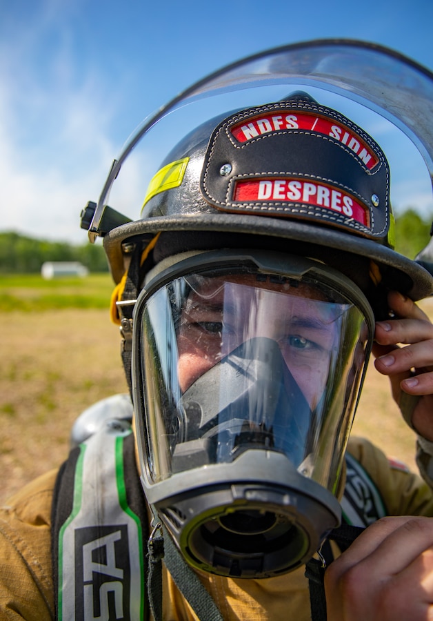 A Canadian firefighter with Canadian Forces Base Cold Lake puts on a protective mask during combined training with U.S. Marine Reservists at CFB Cold Lake, Canada, June 16, 2019, in support of Sentinel Edge 19. The Marine Reserve plays a critical component to the Marine Corps’ Total Force, and training such as SE19 helps ensure Reserve units combat effectiveness and proficiency for world-wide deployment. (U.S. Marine Corps photo by Sgt. Andy O. Martinez)