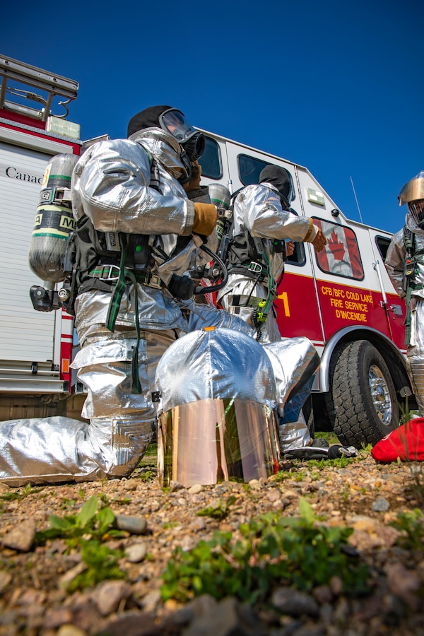 A U.S. Marine aircraft rescue and firefighting specialist with Marine Wing Support Squadron 471, Marine Aircraft Group 41, 4th Marine Aircraft Wing, puts on a protective helmet during combined firefighting training at Canadian Forces Base Cold Lake, Canada, June 16, 2019, in support of Sentinel Edge 19. The Marine Reserve plays a critical component to the Marine Corps’ Total Force, and training such as SE19 helps ensure Reserve units combat effectiveness and proficiency for world-wide deployment. (U.S. Marine Corps photo by Sgt. Andy O. Martinez)