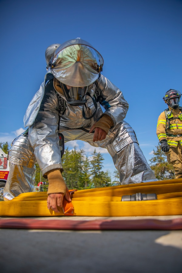 A U.S. Marine aircraft rescue and firefighting specialist with Marine Wing Support Squadron 471, Marine Aircraft Group 41, 4th Marine Aircraft Wing, prepares to use a fire hose during combined firefighting training at Canadian Forces Base Cold Lake, Canada, June 16, 2019, in support of Sentinel Edge 19. The Marine Reserve plays a critical component to the Marine Corps’ Total Force, and training such as SE19 helps ensure Reserve units combat effectiveness and proficiency for world-wide deployment. (U.S. Marine Corps photo by Sgt. Andy O. Martinez)