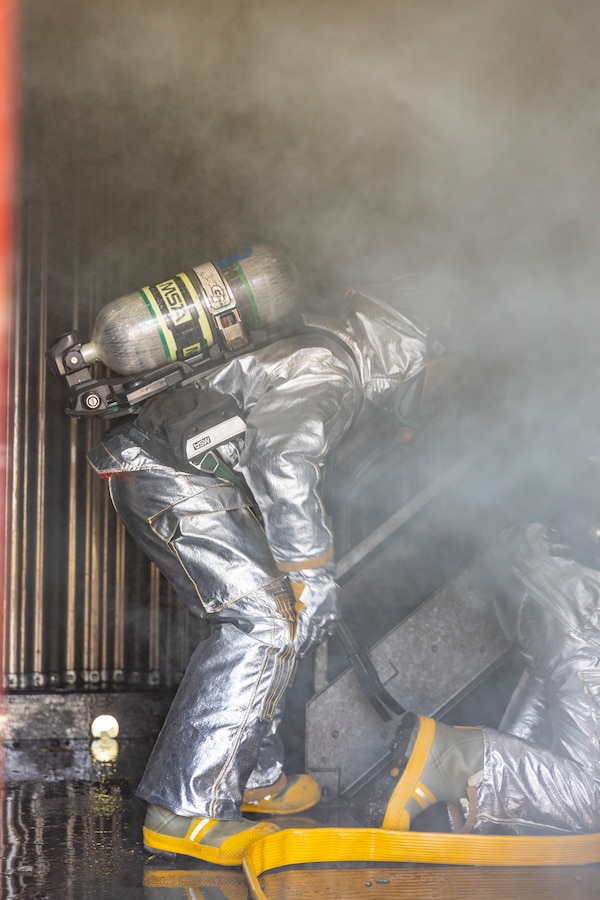 U.S. Marine aircraft rescue and firefighting specialists with Marine Wing Support Squadron 471, Marine Aircraft Group 41, 4th Marine Aircraft Wing, extinguish a fire in a burning room during combined firefighting training at Canadian Forces Base Cold Lake, Canada, June 16, 2019, in support of Sentinel Edge 19. The Marine Reserve plays a critical component to the Marine Corps’ Total Force, and training such as SE19 helps ensure Reserve units combat effectiveness and proficiency for world-wide deployment. (U.S. Marine Corps photo by Sgt. Andy O. Martinez)
