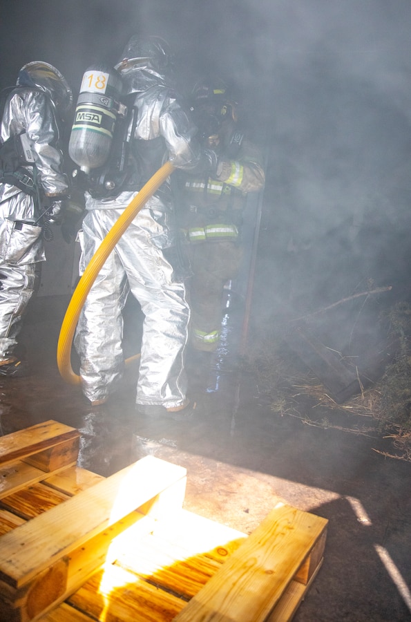 U.S. Marine aircraft rescue and firefighting specialists with Marine Wing Support Squadron 471, Marine Aircraft Group 41, 4th Marine Aircraft Wing, extinguish a fire in a burning room with Canadian firefighters during combined firefighting training at Canadian Forces Base Cold Lake, Canada, June 16, 2019, in support of Sentinel Edge 19. The Marine Reserve plays a critical component to the Marine Corps’ Total Force, and training such as SE19 helps ensure Reserve units combat effectiveness and proficiency for world-wide deployment. (U.S. Marine Corps photo by Sgt. Andy O. Martinez)