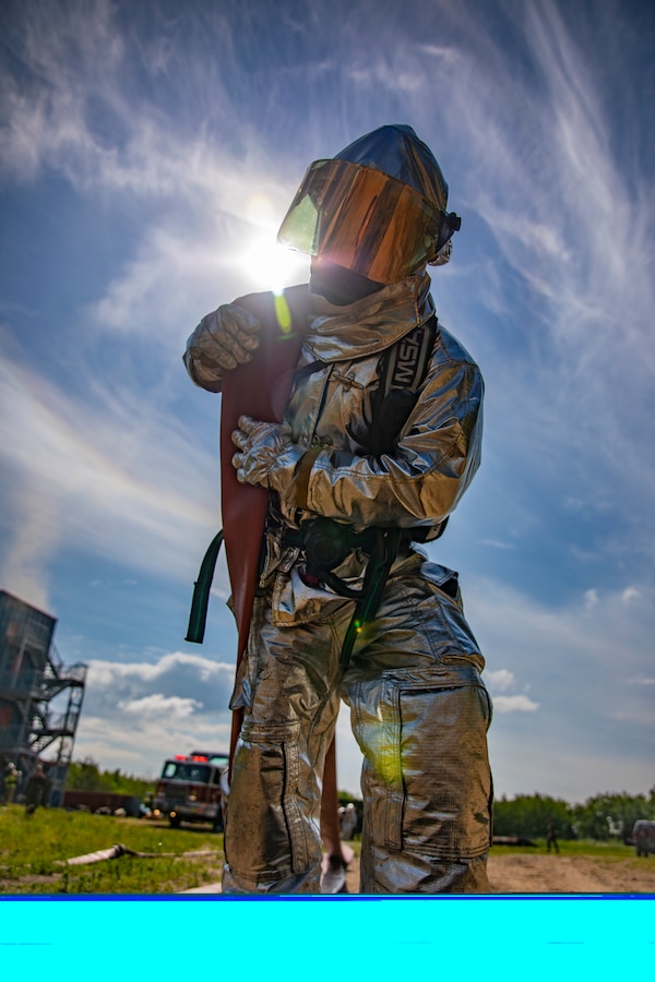 A U.S. Marine aircraft rescue and firefighting specialist with Marine Wing Support Squadron 471, Marine Aircraft Group 41, 4th Marine Aircraft Wing, drags a fire hose during combined firefighting training at Canadian Forces Base Cold Lake, Canada, June 16, 2019, in support of Sentinel Edge 19. The Marine Reserve plays a critical component to the Marine Corps’ Total Force, and training such as SE19 helps ensure Reserve units combat effectiveness and proficiency for world-wide deployment. (U.S. Marine Corps photo by Sgt. Andy O. Martinez)