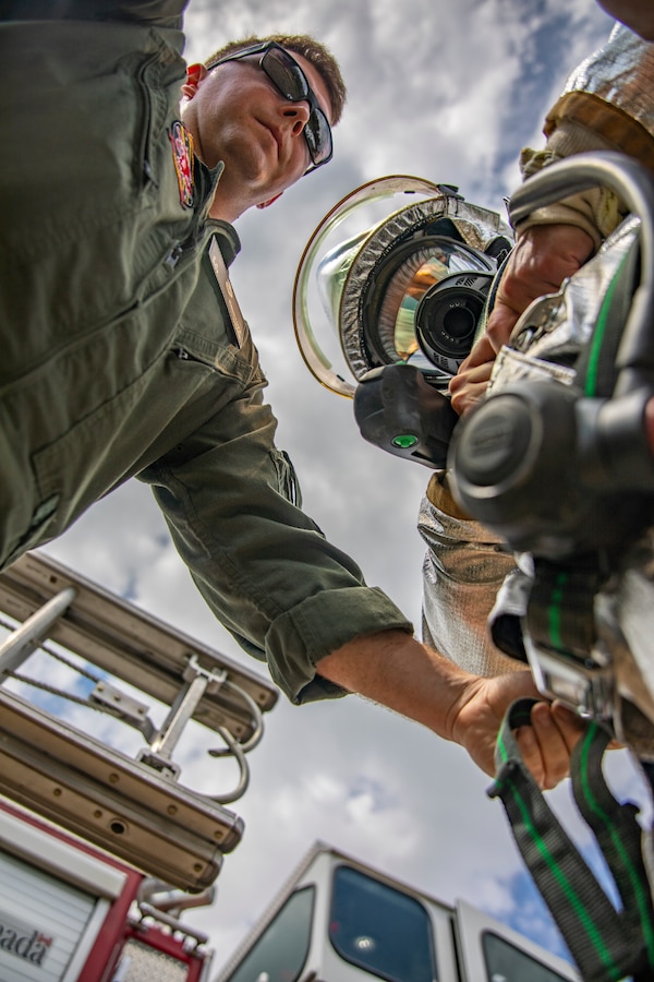 A U.S. Marine aircraft rescue and firefighting specialist with Marine Wing Support Squadron 471, Marine Aircraft Group 41, 4th Marine Aircraft Wing, assist another Marine with putting on his gear during combined firefighting training at Canadian Forces Base Cold Lake, Canada, June 16, 2019, in support of Sentinel Edge 19. The Marine Reserve plays a critical component to the Marine Corps’ Total Force, and training such as SE19 helps ensure Reserve units combat effectiveness and proficiency for world-wide deployment. (U.S. Marine Corps photo by Sgt. Andy O. Martinez)