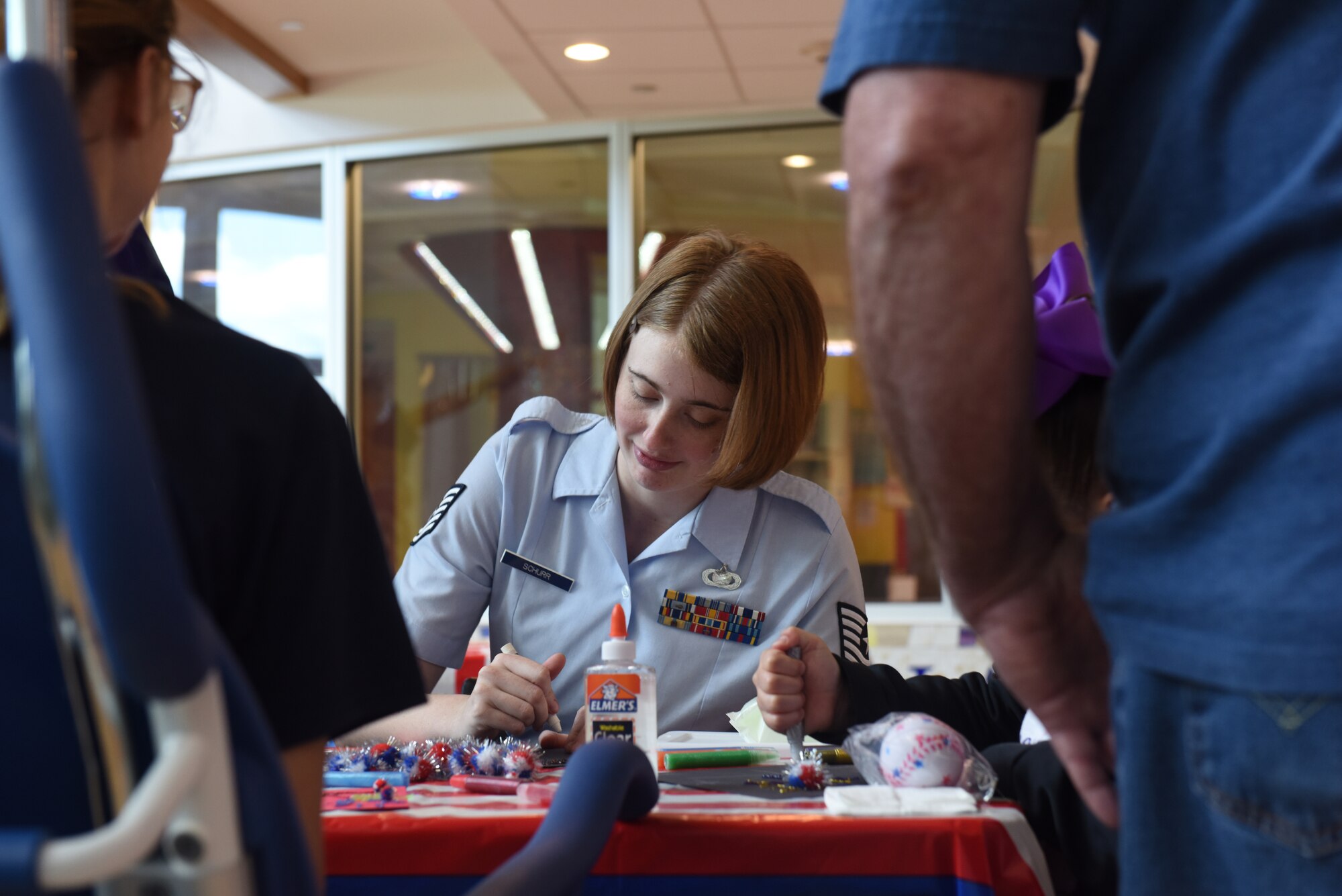 Tech. Sgt. Marjorie A. Schurr, NCO in charge of community engagement with the 911th Airlift Wing, makes glitter glue fireworks with patients and their families at Children’s Hospital of Pittsburgh, June 14, 2019.