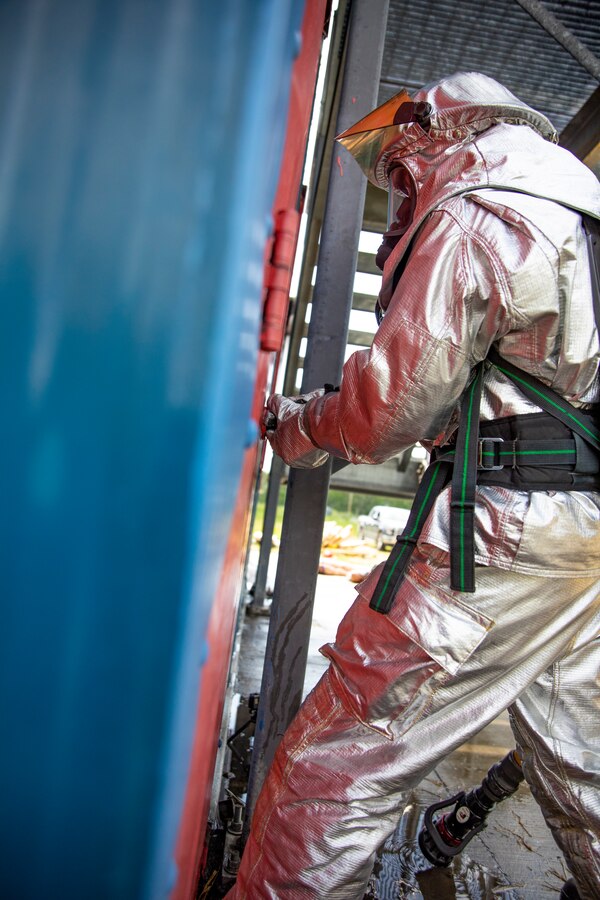 A U.S. Marine aircraft rescue and firefighting specialist with Marine Wing Support Squadron 471, Marine Aircraft Group 41, 4th Marine Aircraft Wing, turns a door knob to enter a burning room during combined firefighting training at Canadian Forces Base Cold Lake, Canada, June 16, 2019, in support of Sentinel Edge 19. The Marine Reserve plays a critical component to the Marine Corps’ Total Force, and training such as SE19 helps ensure Reserve units combat effectiveness and proficiency for world-wide deployment. (U.S. Marine Corps photo by Sgt. Andy O. Martinez)
