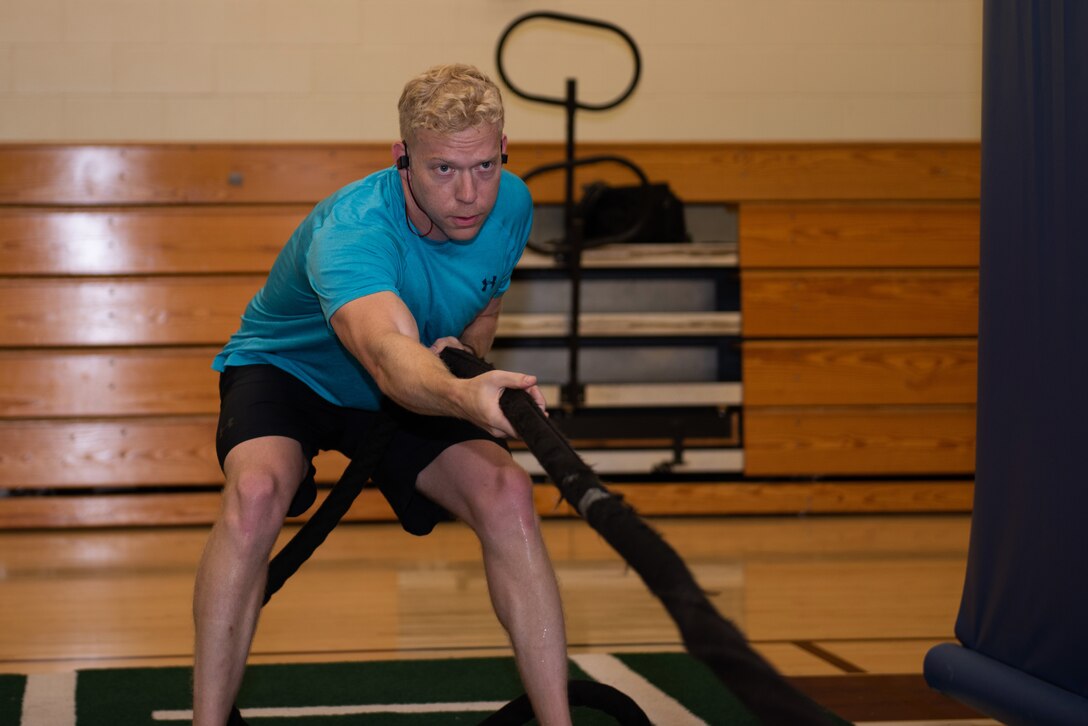 U.S. Air Force Capt. Christopher Williston, a 21st Airlift Squadron C-17 Globemaster III pilot from Baton Rouge, Louisiana, pulls weights toward him during a workout June 13, 2019, at Travis Air Force Base, California. Williston is training to compete in the Alpha Warrior Western Regional Competition June 21 at Hill AFB, Utah. (U.S. Air Force photo by Tech. Sgt. James Hodgman)