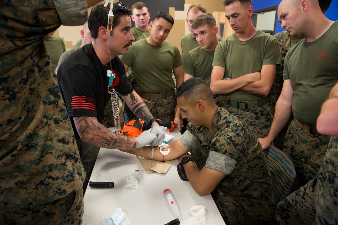 U.S. Navy Corpsman HM2 Max Sechler, Marine Corps Air Station Yuma Search and Rescue, demonstrates an IV lab for U.S. Marines following Combat Lifesaver (CLS) Course at MCAS Yuma Ariz., May 14, 2019. The CLS Course is a two-week long evaluation that teaches service members how to properly apply life-saving medical treatmemt to injured service members in any environment (U.S. Marine Corps photo by Lance Cpl. Joel Soriano)