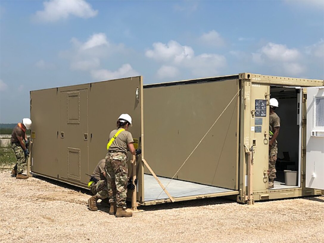 Expeditionary disposal team members prepare a command and control shelter at Camp Bondsteel in Kosovo. The military-civilian team will spend two weeks in the Slavic nation helping U.S. Army units discard a wide variety of accumulated used materiel.