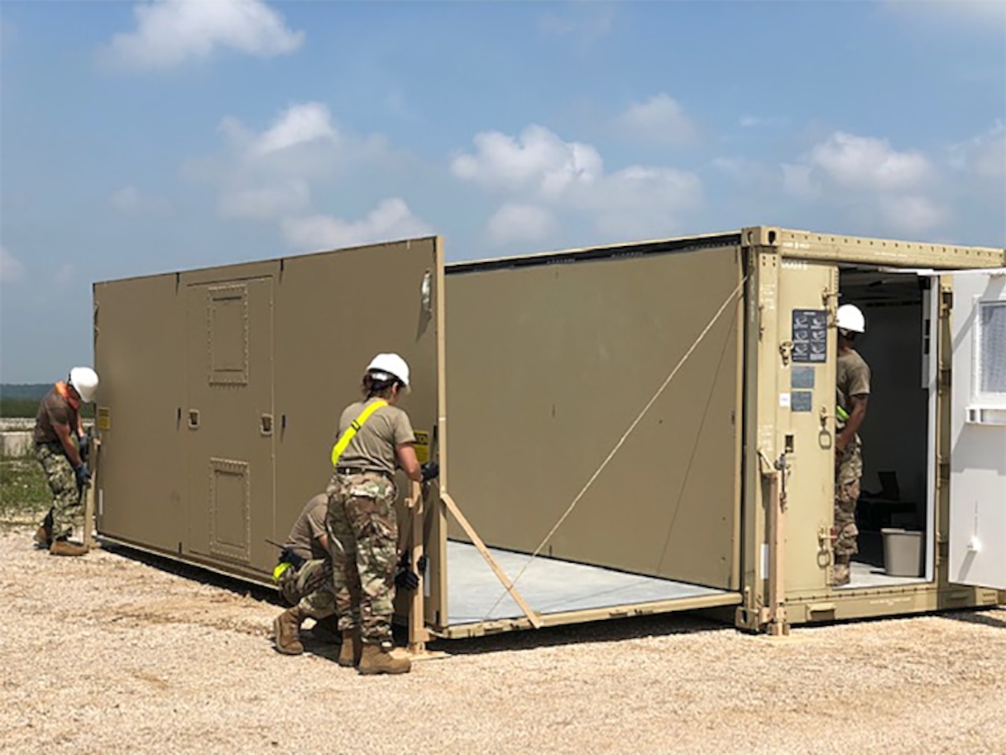 Expeditionary disposal team members prepare a command and control shelter at Camp Bondsteel in Kosovo. The military-civilian team will spend two weeks in the Slavic nation helping U.S. Army units discard a wide variety of accumulated used materiel.