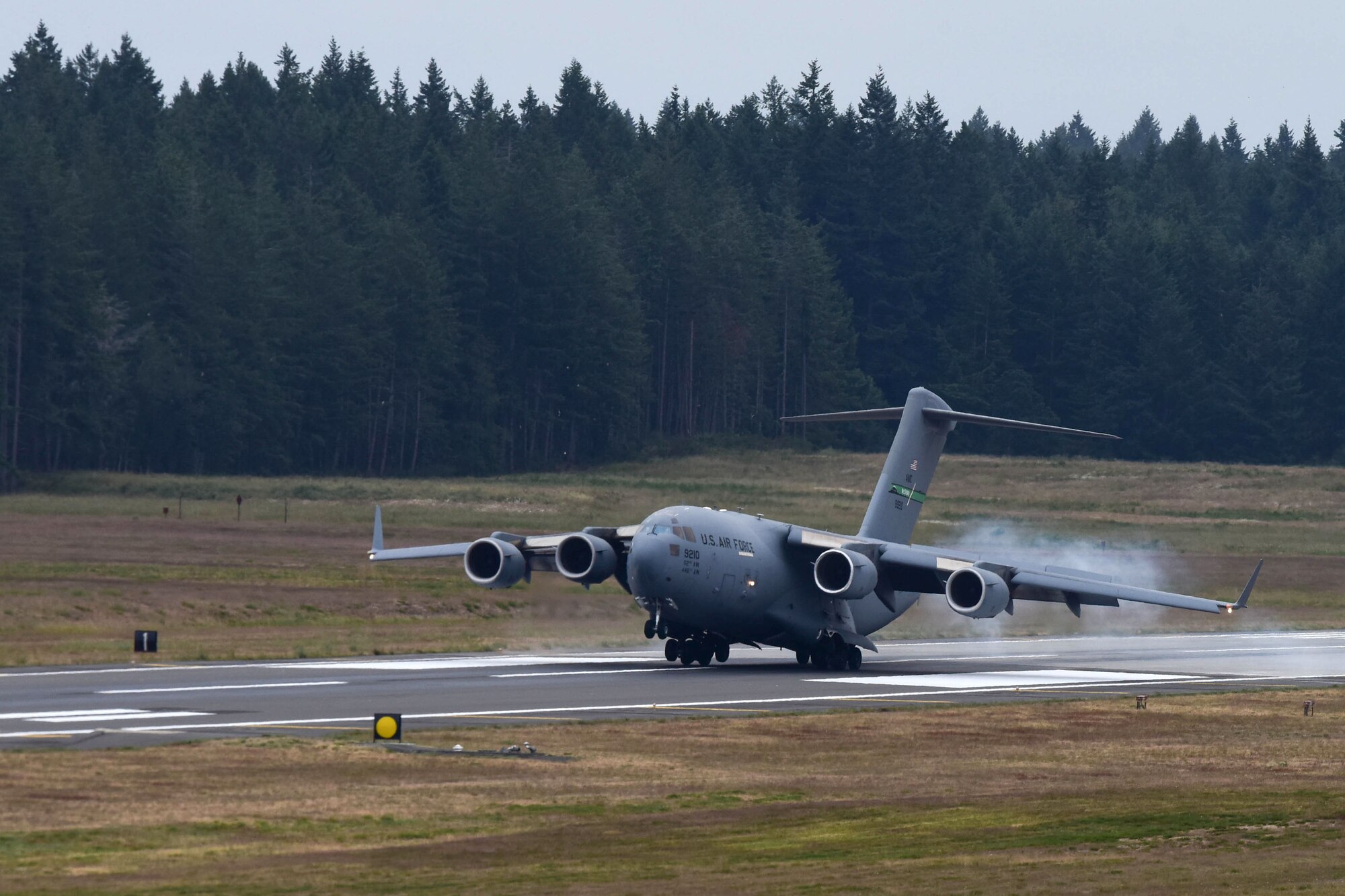 The first aircraft lands on the newly resurfaced runway at McChord Field, June 17, 2019, at Joint Base Lewis-McChord. McChord Field aircraft and Airmen continued operations at other west coast bases while the runway was resurfaced.  (U.S. Air Force photo by Airman 1st Class Sara Hoerichs)