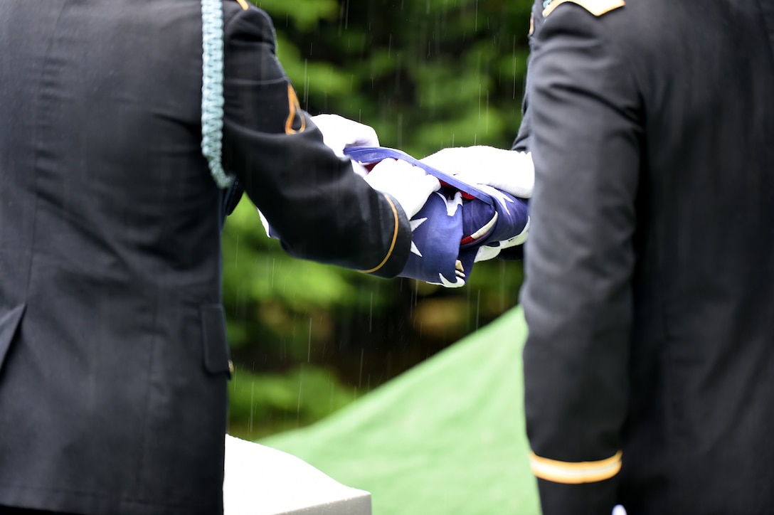 Soldiers from the 101st Airborne Division fold the flag during a graveside service for Staff Sgt. Al Mampre. Mampre served as a medic with Easy Company, 2nd Battalion, 506th Parachute Infantry Regiment, 101st Airborne Division during World War II.