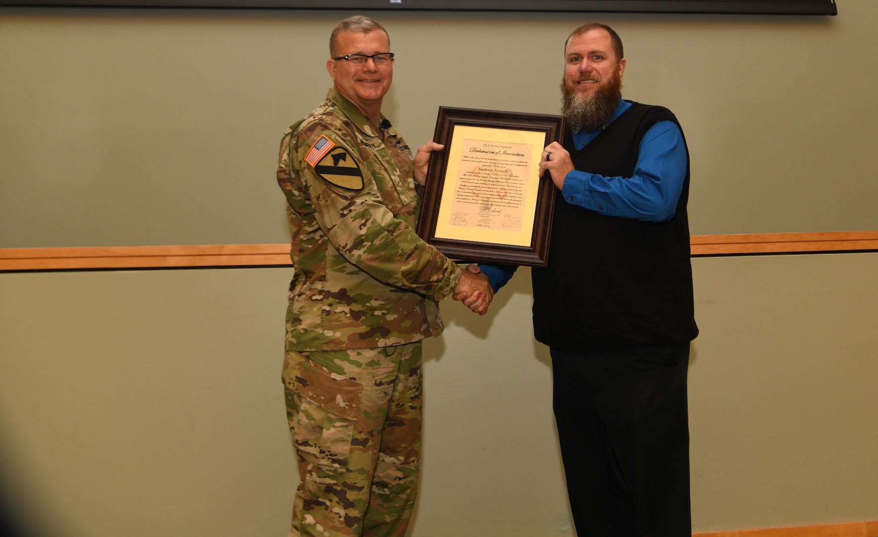 Defense Logistics Agency Troop Support commander Army Brig. Gen. Mark Simerly presents the DLA Troop Support Declaration of Innovation to Andrew Nemeth during a Town Hall in Philadelphia, June 11, 2019. Nemeth, a quality assurance specialist in DLA Troop Support’s Industrial Hardware supply chain, was instrumental in streamlining the Product Quality Deficiency Report process. (Photo by Ed Maldonado /DLA Troop Support)