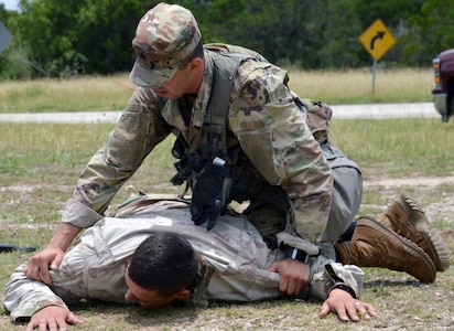 Army Sgt. Kevin Ramirez takes down an aggressor during the tactical road march portion of the Brooke Army Medical Center Best Medic Competition at Joint Base San Antonio-Camp Bullis June 12. The competitors were tested on both warrior and medic skills during the competition.