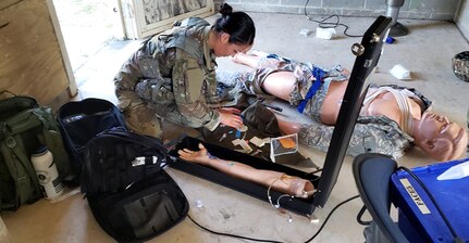 Army Sgt. Samantha Delgado assesses a patient during the medical lane portion of the Brooke Army Medical Center Best Medic Competition at Joint Base San Antonio-Camp Bullis June 12. The Soldiers competed in several warrior and medical tasks during the grueling competition.