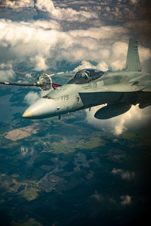 A Royal Canadian Air Force CF-188 Hornet from 409 Tactical Fighter Squadron, Canadian Forces Base Cold Lake is aerial refueled by a KC-130 Hercules from Marine Aerial Refueler Transport Squadron 234, Marine Aircraft Group 41, 4th Marine Aircraft Wing, during an aerial refueling training mission in the air over Cold Lake, Canada, June 17, 2019, in support of Sentinel Edge 19. MARFORRES squadrons participate in SE19 to both complete annual training requirements and to increase unit readiness and proficiency. (U.S. Marine Corps photo by Sgt. Andy O. Martinez)