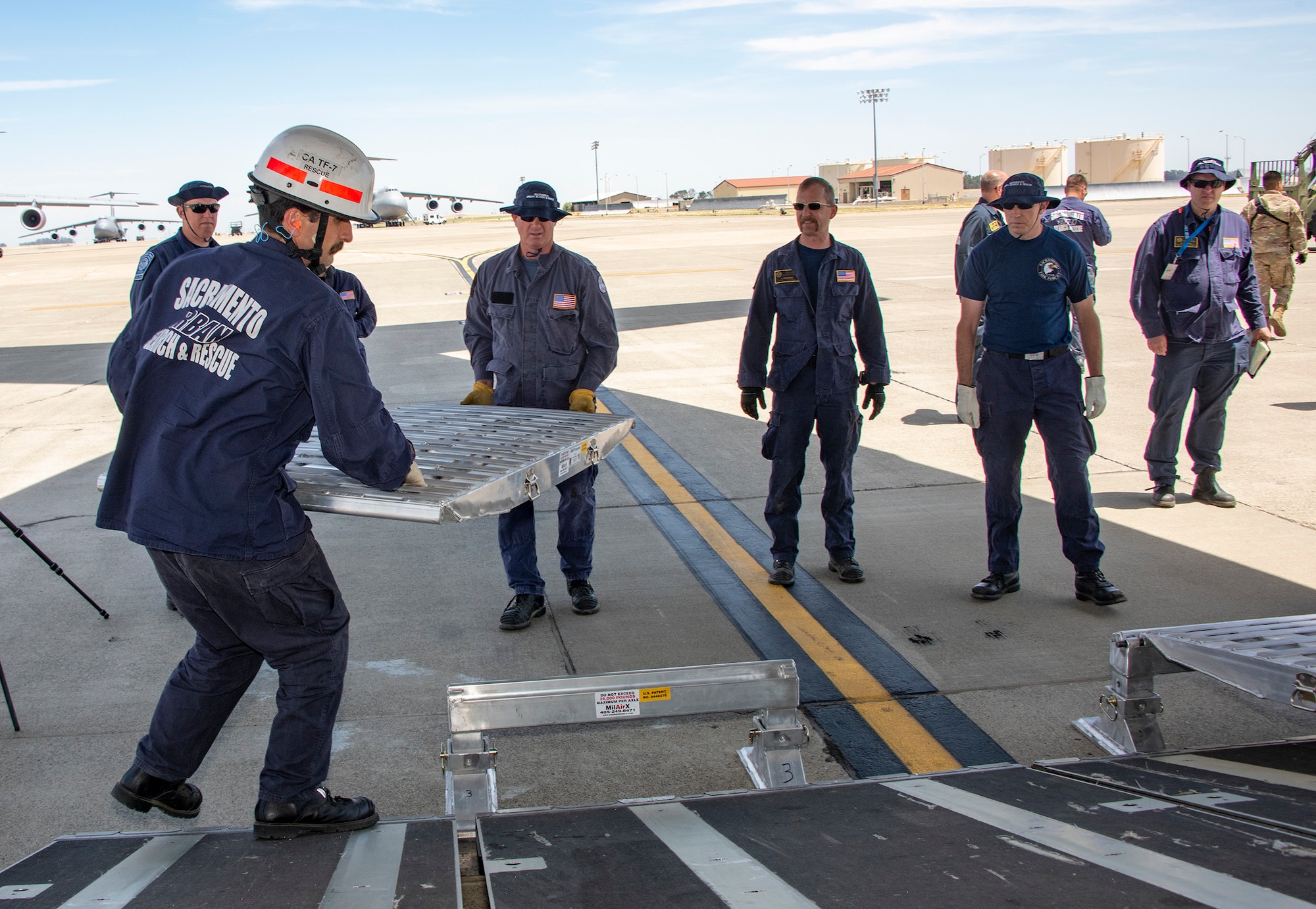 California Urban Search and Rescue Task Force 7 team members position vehicle ramps at the aft cargo bay door of a C-17 Globemaster III during a joint inspection and logistics drill conducted with 60th Aerial Port Squadron personnel June 13, 2019, at Travis Air Force Base, California. The annual training helps members of CA TF-7 learn about the process, governing and directives and ensures cargo is safe before loading onto an aircraft.  (U.S. Air Force photo by Heide Couch)