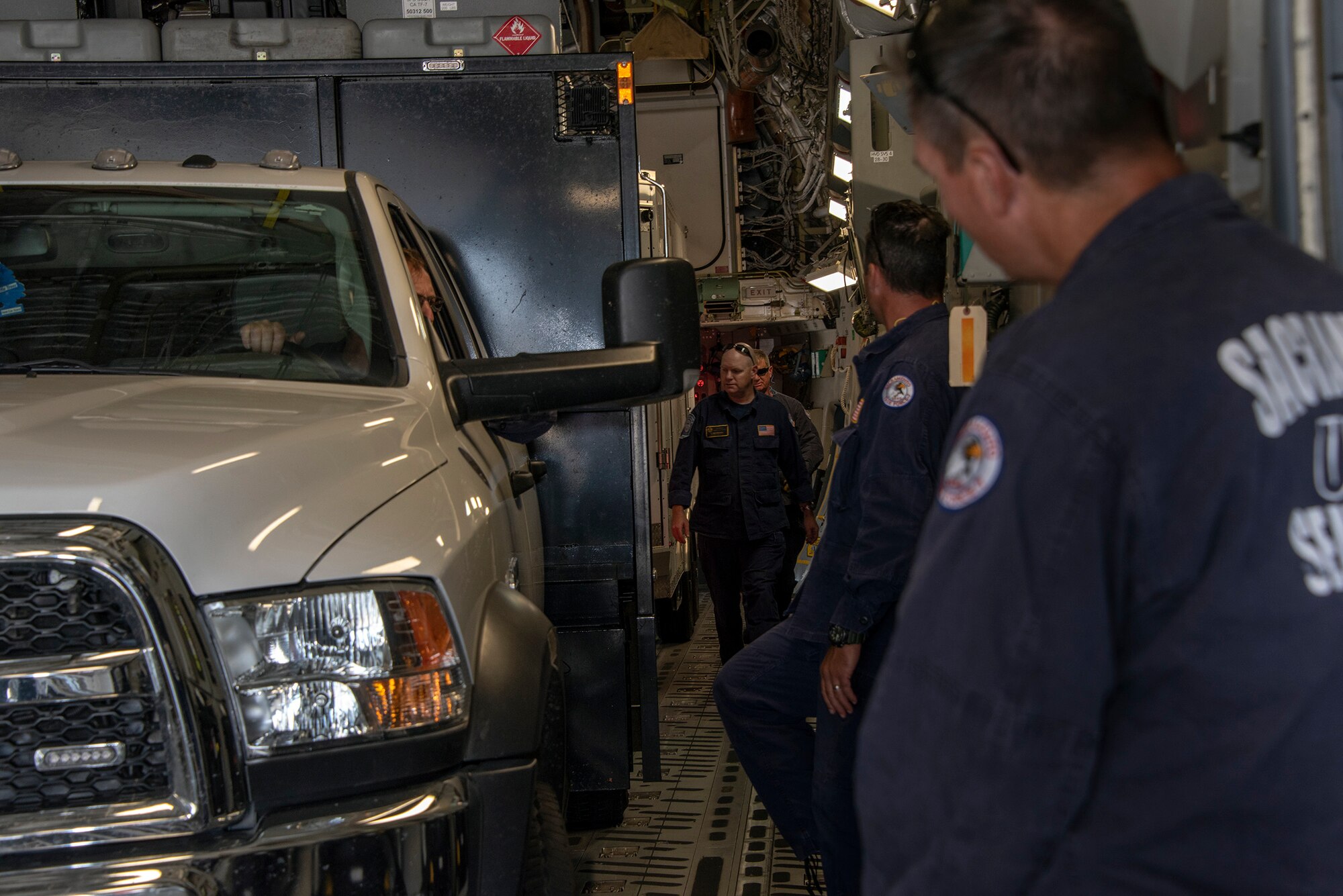 California Urban Search and Rescue Task Force 7 checks the position of a cargo transport trailer inside the bay of a C-17 Globemaster III during a joint inspection and logistics drill conducted with 60th Aerial Port Squadron personnel, June 13, 2019, at Travis Air Force Base, California. The annual training helps members of CA TF-7 learn about the process, governing and directives and ensures cargo is safe before loading onto an aircraft.  (U.S. Air Force photo by Heide Couch)