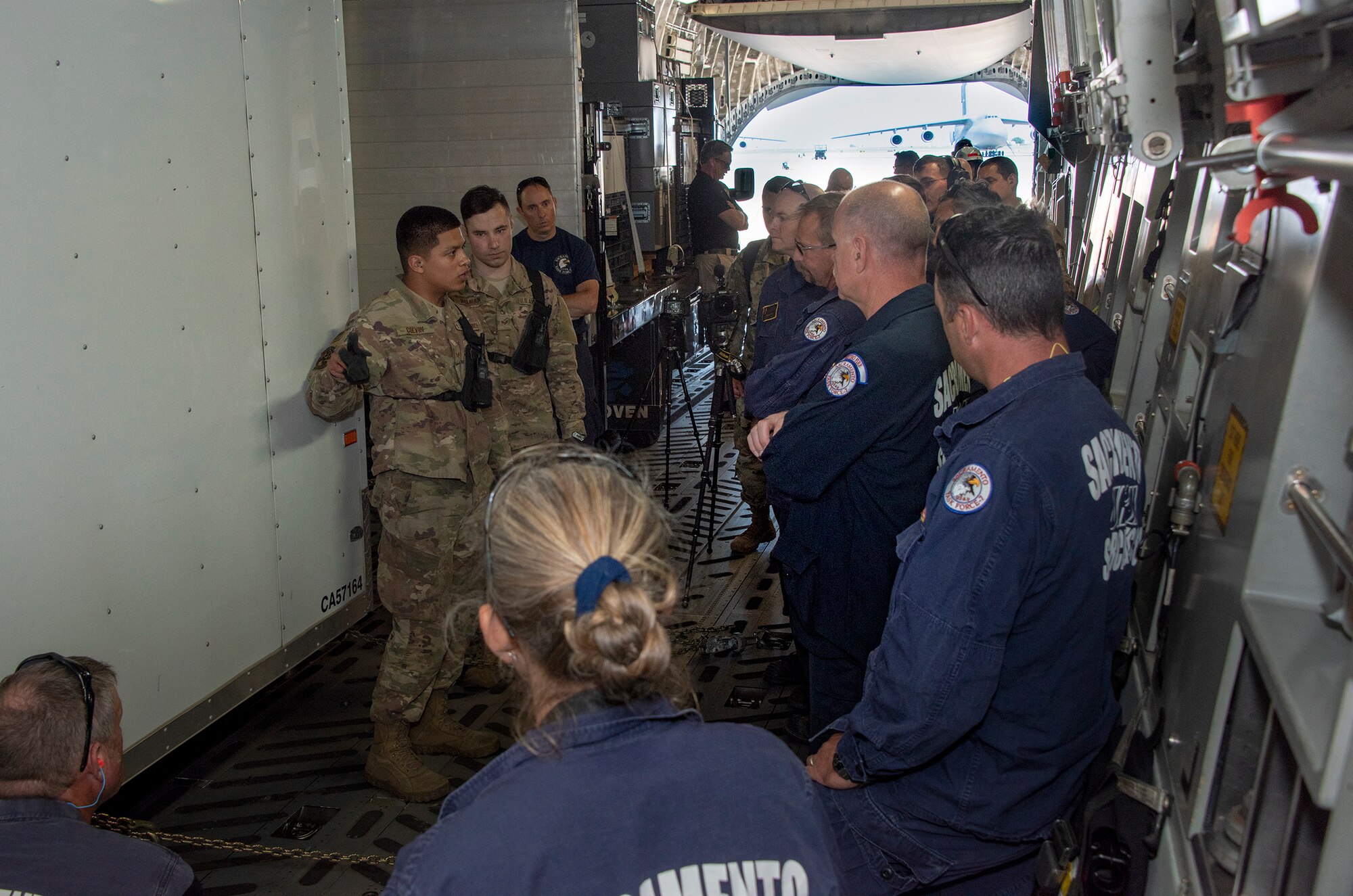 U.S. Air Force Senior Airman Edward Colvin, left, 60th Aerial Port Squadron expeditor, discuses cargo loading procedure with California Urban Search and Rescue Task Force 7 June 13, 2019, at Travis Air Force Base, California. The annual training helps members of CA TF-7 learn about the process, governing and directives and ensures cargo is safe before loading onto an aircraft.  (U.S. Air Force photo by Heide Couch)