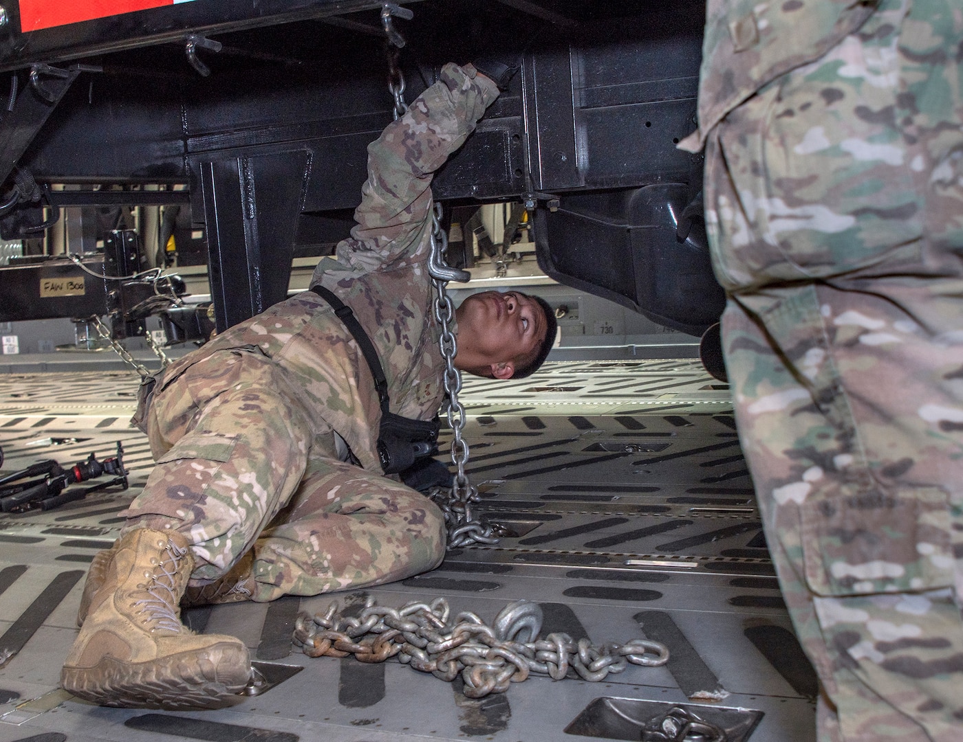 U.S. Air Force Senior Airman Edward Colvin, 60th Aerial Port Squadron expeditor, uses a chain to secure an equipment transport trailer to the deck of a C-17 Globemaster III during a joint inspection and logistics drill conducted with California Urban Search and Rescue Task Force 7 June 13, 2019 at Travis Air Force Base, California. The annual training helps members of CA TF-7 learn about the process, governing and directives and ensures cargo is safe before loading onto an aircraft.  (U.S. Air Force photo by Heide Couch)