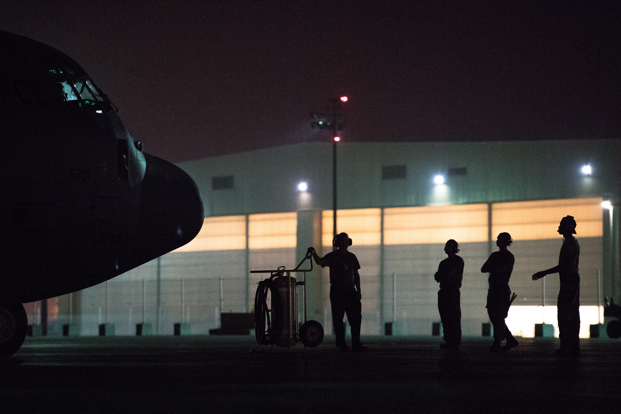 U.S. Air Force Airmen assigned to the 75th Expeditionary Airlift Squadron wait for further instruction before directing a C-130J Super Hercules on the flightline at Camp Lemonnier, Djibouti, June 5, 2019. The 75th EAS provides support in medical evacuations, disaster relief, humanitarian and airdrop operations. (U.S. Air Force photo by Staff Sgt. Devin Boyer)