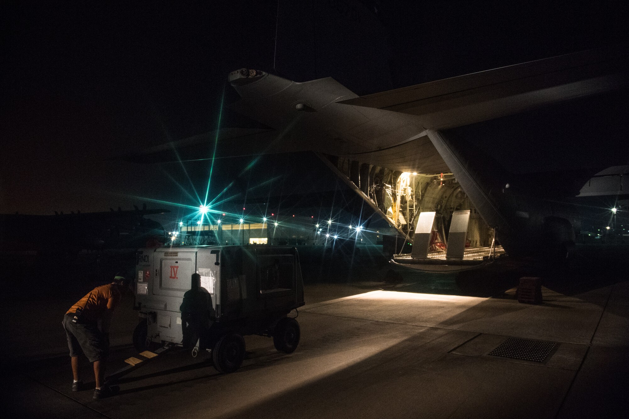 An air operations member prepares a generator before loading it onto a C-130J Super Hercules with the help of 75th Expeditionary Airlift Squadron Airmen at Camp Lemonnier, Djibouti, June 5, 2019. The 75th EAS provides support in medical evacuations, disaster relief, humanitarian and airdrop operations. (U.S. Air Force photo by Staff Sgt. Devin Boyer)