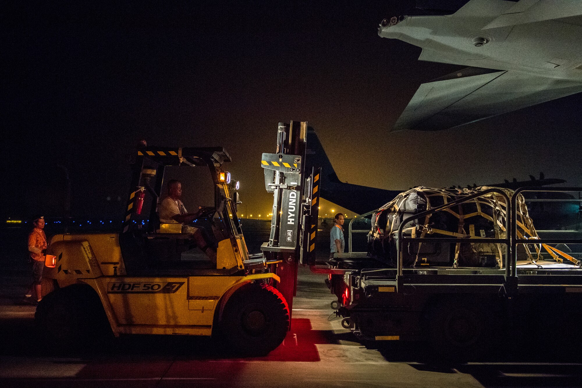 An air operations member loads luggage onto a C-130J Super Hercules with the help of 75th Expeditionary Airlift Squadron Airmen at Camp Lemonnier, Djibouti, June 5, 2019. The 75th EAS provides support in medical evacuations, disaster relief, humanitarian and airdrop operations. (U.S. Air Force photo by Staff Sgt. Devin Boyer)