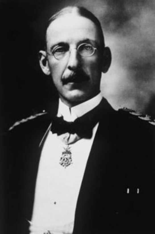 A man in 1800s-era suit and glasses poses with the Medal of Honor around his neck.