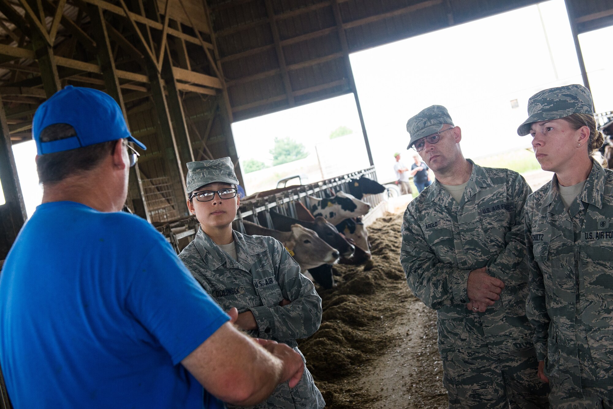 (from left) U.S. Air Force Tech. Sgt. Erika Dolinsek, a public health specialist assigned to the 176th Wing, Alaska Air National Guard; U.S. Air Force Staff Sgt. Richard Arold, a public health specialist assigned to the 175th Wing, Maryland Air National Guard; and U.S. Air Force Staff Sgt. Jessica Schultz, a bioenvironmental engineering specialist assigned to the 175th Wing, Maryland Air National Guard, speak with Wayne Lohmann, a farmer at Lohmann Farms, in Perryville, Mo., June 18, 2019. The Airmen coordinated with civilian public health agency partners to view livestock processes and promote interagency cooperation. (U.S. Air National Guard photo by Senior Airman Jonathan W. Padish)