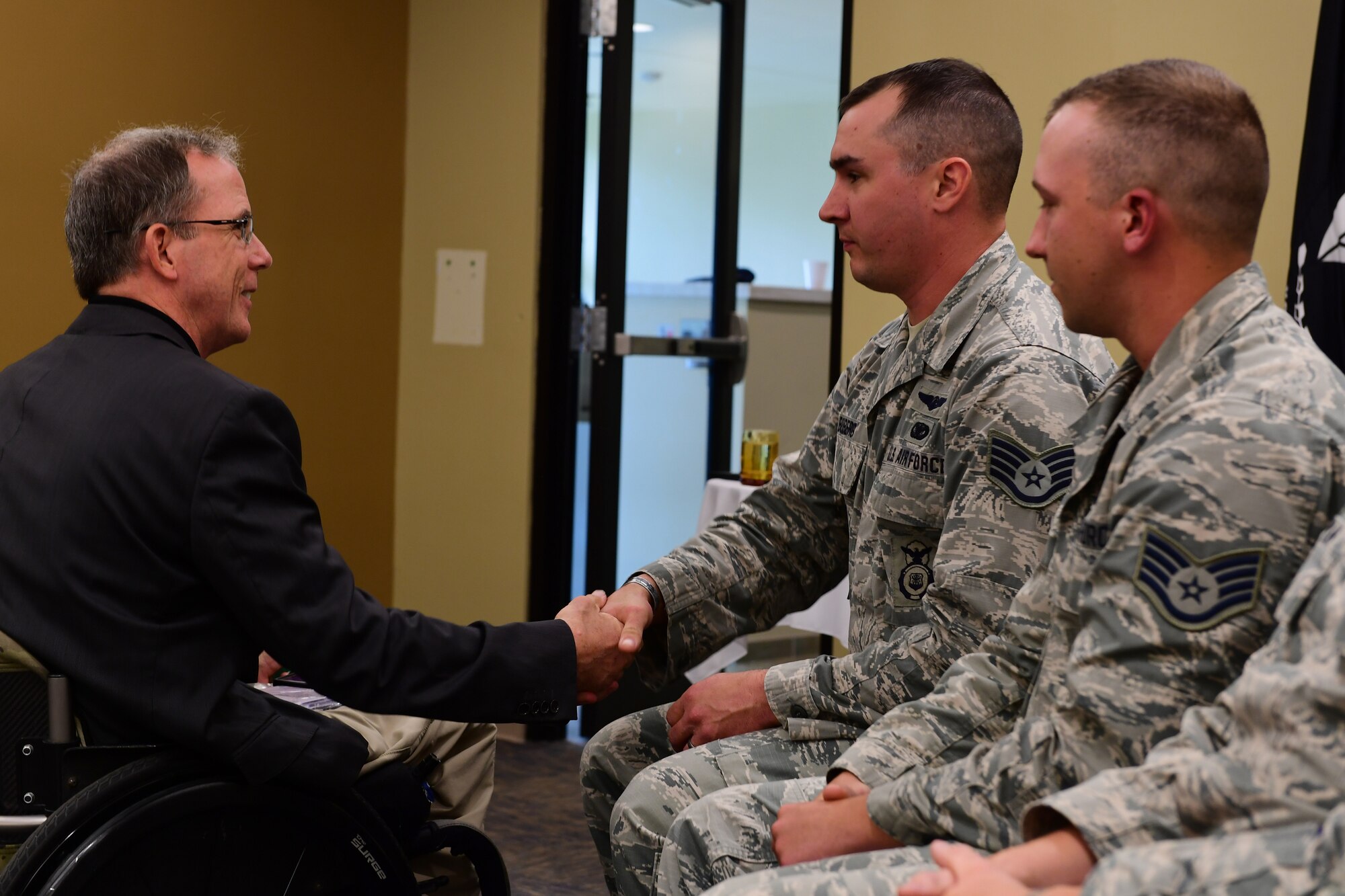 Guest speaker Dr. Rory A. Cooper, congratulates members of the 911th Security Forces Squadron on being promoted to the Noncommisioned Officer ranks during an NCO promotion and induction ceremony at the Pittsburgh International Airport Air Reserve Station, Pennsylvania, June 2, 2019. Dr. Cooper is the director of the Paralyzed Veterans of America Research Foundation.