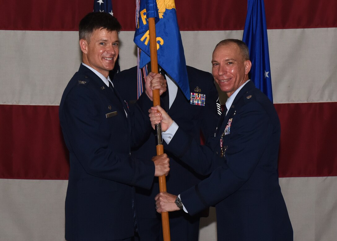 U.S. Air Force Col. Thomas Coakley, 17th Training Group commander, accepts the guidon from Lt. Col. Scott Cline, outgoing 312th Training Squadron commander, during the change of command ceremony at the Louis F. Garland Department of Defense Fire Academy High Bay on Goodfellow Air Force Base, Texas, June 19, 2019. The 312th trains fire emergency services and scientific applications specialists who will work on all seven continents. (U.S. Air Force photo by Airman 1st Class Zachary Chapman/Released)